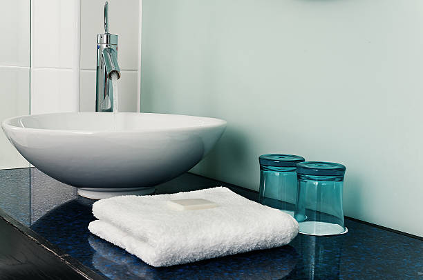 Bathroom sink counter towels water glass blue stock photo