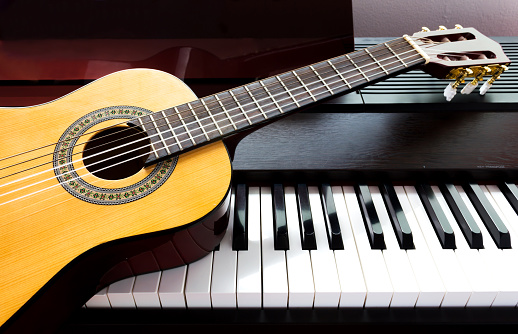 Young woman is looking for guitar in musical instruments store.