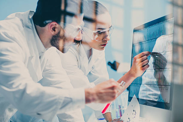 scientists looking at a DNA sequence on the monitor