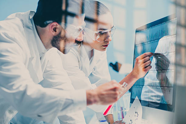 scientists looking at a DNA sequence on the monitor stock photo