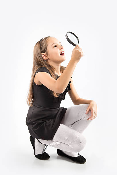 istock Cute little girl looking through a magnifying glass 499926742