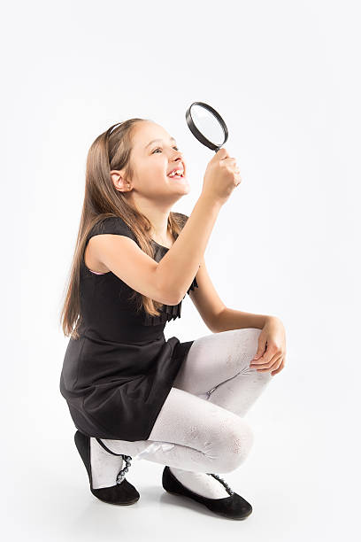 istock Cute little girl looking through a magnifying glass 499926814