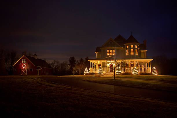 Victorian House at Christmas A beautiful Victorian style house and traditional barn decorated for Christmas. christmas lights house stock pictures, royalty-free photos & images