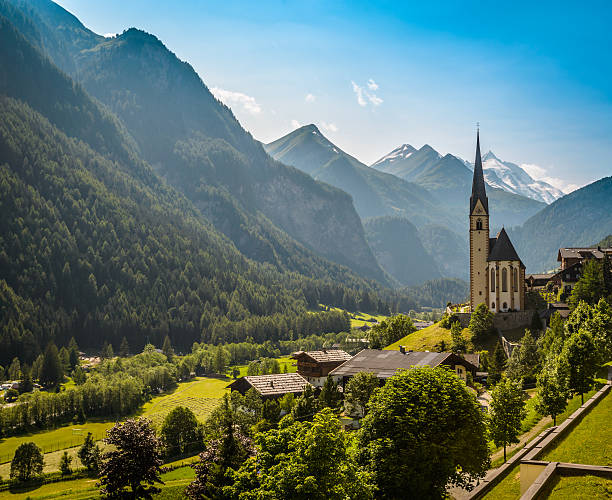Heiligenblut Rural landscape of Heiligenblut with St Vincent Church in Carynthia and Grossglockner (3797 m. elevation) highest mountain from Austria in background. grossglockner stock pictures, royalty-free photos & images