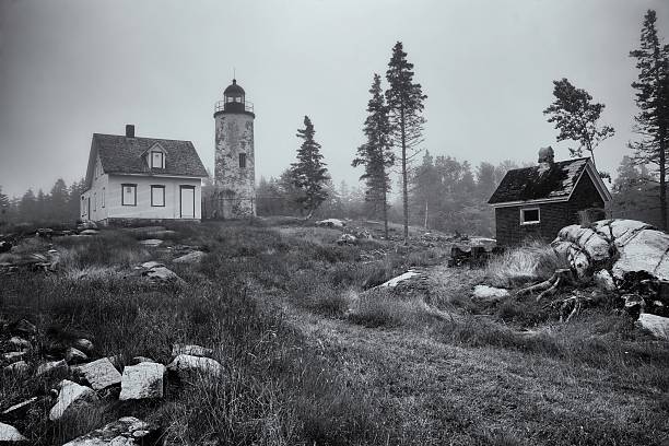 A Black and White image of the Baker Island Lighthouse in Acadia National Park, Maine, USA, on a foggy day.