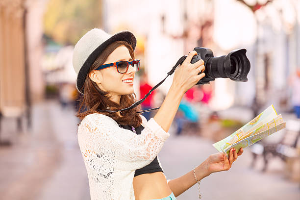 istock Young woman wearing sunglasses shoots with camera 499953856