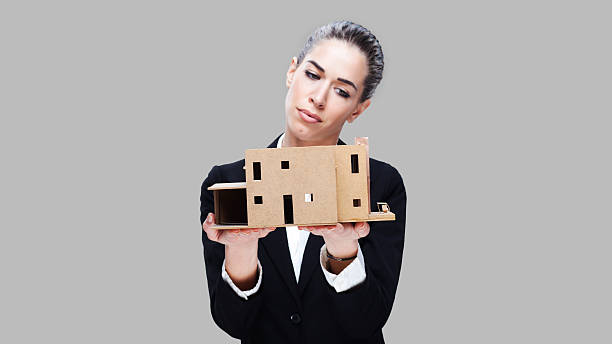 istock Female business agent holding house model 499955984