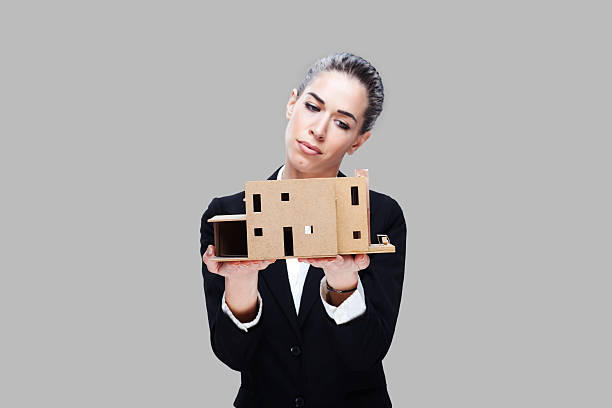 istock Female business agent holding house model 499955994