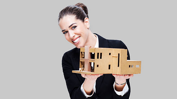 istock Female business agent holding house model 499956004