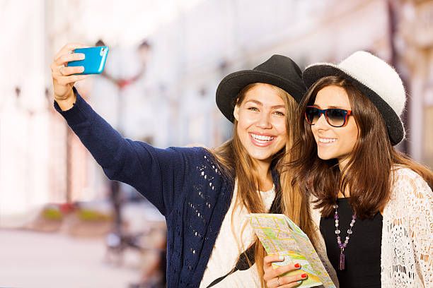 istock Two cute girls taking selfies with mobile phone 499956872