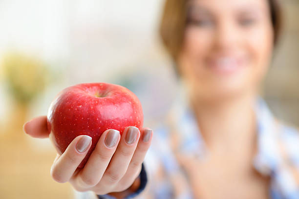 istock Red apple in girls hand 499977548