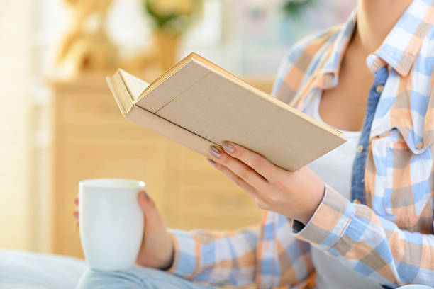 istock Girl is drinking tea and reading book 499977820