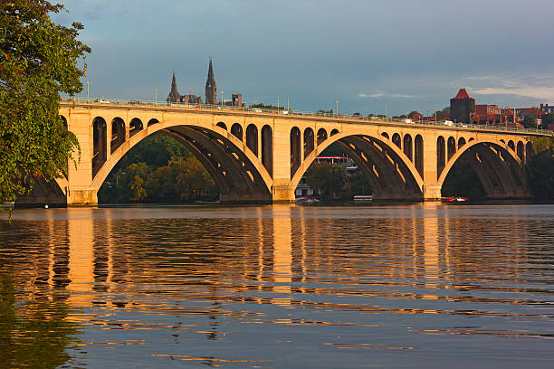 Francis Scott Key Bridge and Georgetown skyline with reflections.