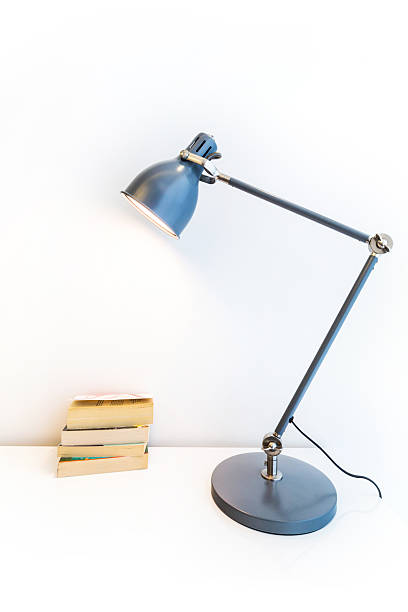 istock lamp and books on white background 499979805