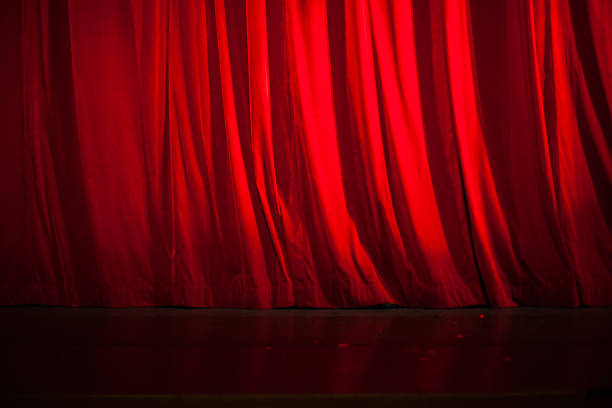 istock Light Shining on the Red Curtain and Stage Floor 499979974