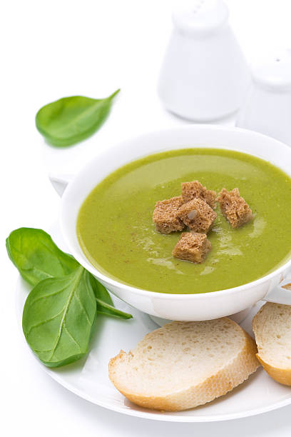 delicious spinach soup with croutons, close-up, isolated on white