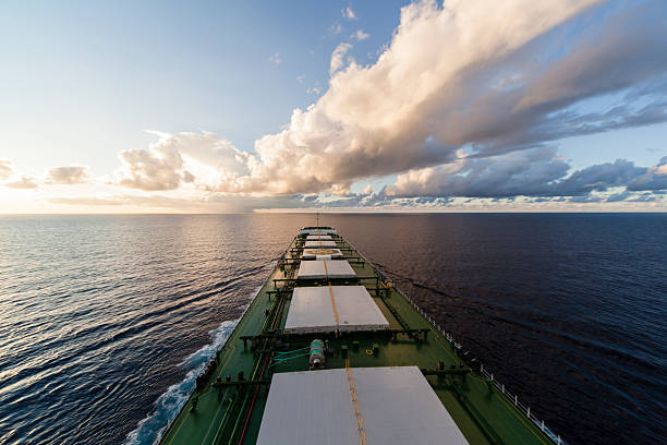 Cargo ship underway at sunset stock photo