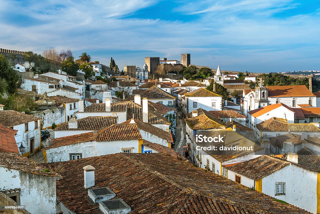 Obidos - landmark A view of the fortified wall in Obidos, Portugal. The name Obidos probably derives from the Latin term oppidum, meaning citadel, or fortified cityObidos is located on a hill and is encircled by a fortified wall. The well-preserved medieval look of its streets, squares, walls and its massive castle have turned the picturesque village into a preferred tourist attraction in Portugal. In latin Obidos mean fotified city Ancient Stock Photo