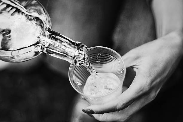 Girl pours alcohol from bottle into glass