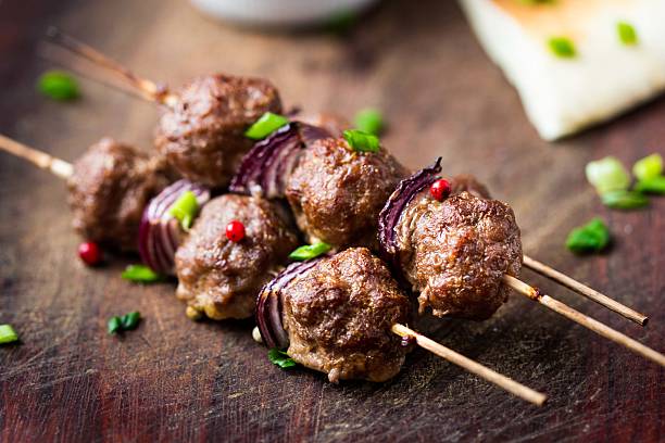 Meat kebab, beef balls on skewer with onions, sauce guacamole stock photo