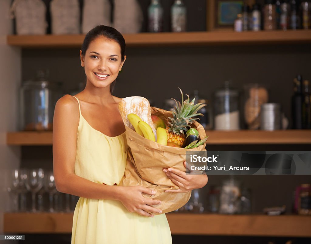 Getting ready to cook up a storm A young woman holding a bag of groceries while looking at the camerahttp://195.154.178.81/DATA/i_collage/pi/shoots/783412.jpg Fruit Stock Photo