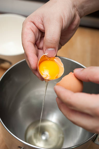 istock cracking eggs and seperate yolk from albumen 500002027
