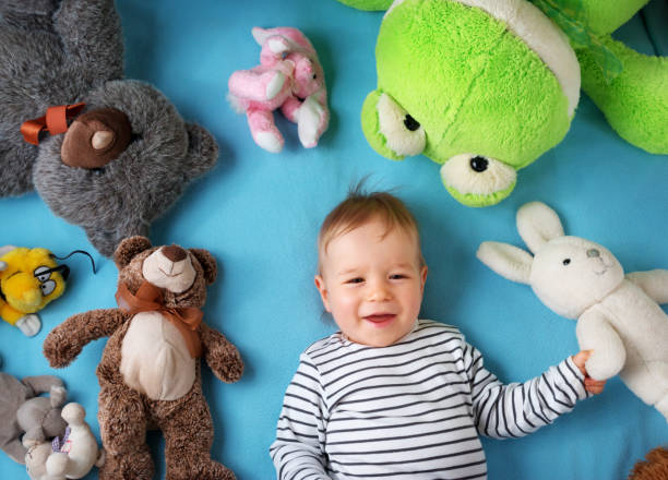 istock Happy one year old boy lying with many plush toys 500004658