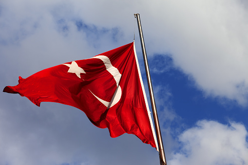 Turkish flag on flagpole at windy sun day