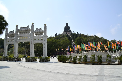 Tourists sightseeing the Po Lin Monastery, surrounded by the giant Tian Tan Buddha statue, located on Ngong Ping Plateau on Lantau Island, Hong Kong.