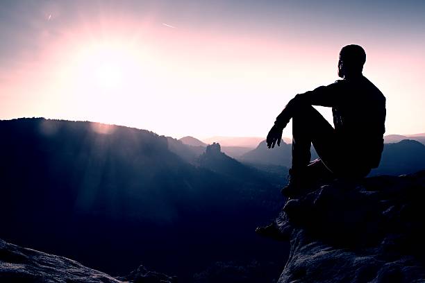 istock Hiker take relaxing on rock and enjoying sunset. Vivid effect. 500018472