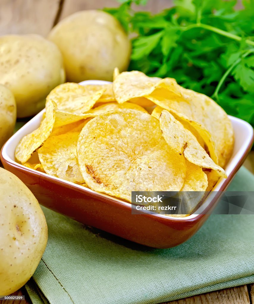- Chips in Schüssel mit Kartoffeln auf Serviette und Bügelbrett - Lizenzfrei Abnehmen Stock-Foto