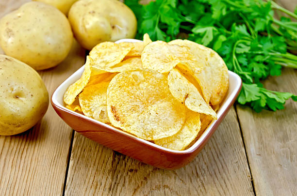istock Chips in clay bowl with potatoes on board 500021261