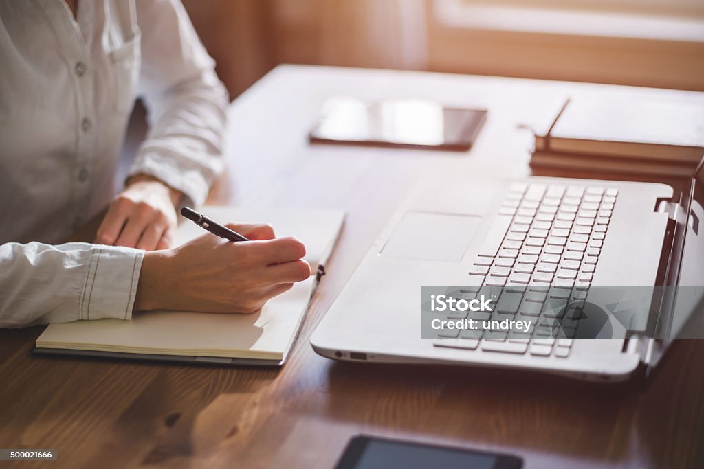 Woman freelancer female hands with pen writing on notebook at Woman freelancer female hands with pen writing on notebook at home or office 2015 Stock Photo