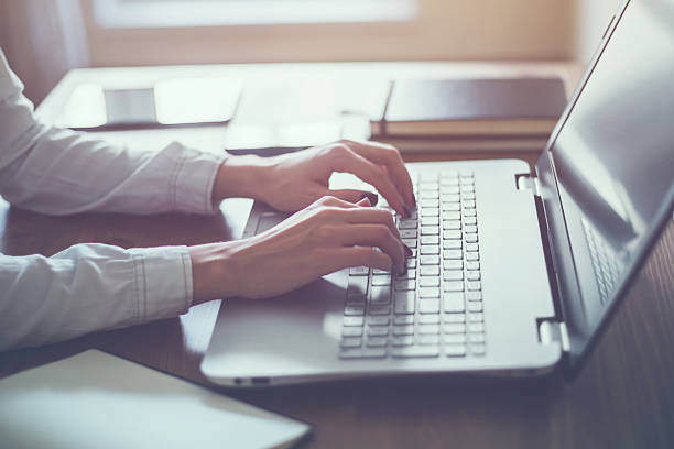 Woman working in home office hand on keyboard close up