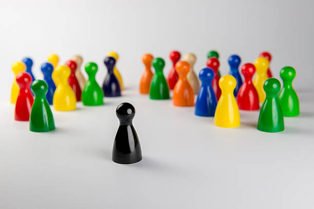 Conceptual game pawns. Conceptual game pawns that depict the concept different. exclusion group of people separation fish out of water stock pictures, royalty-free photos & images