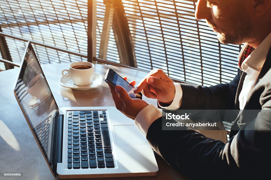 businessman checking email on smartphone business man using internet on  smart phone and laptop Airport Stock Photo