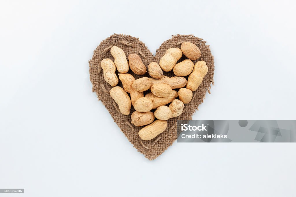 Peanut lies at the heart made of burlap Peanut lies at the heart made of burlap on a white background 2015 Stock Photo