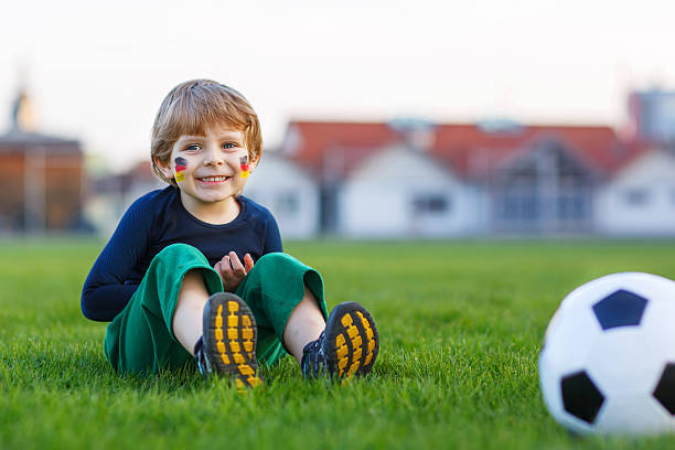 небольшой веер мальчик на общественный просмотр футбол или футбол - playing field goalie soccer player little boys стоковые фото и изображения