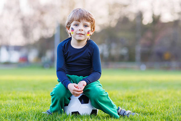 небольшой веер мальчик на общественный просмотр футбол или футбол - playing field goalie soccer player little boys стоковые фото и изображения