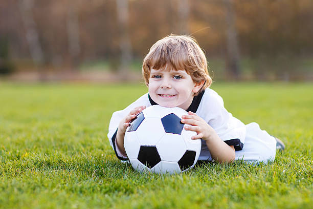 kleinen ventilator junge im öffentlichen anzeige des fußball oder fußball - playing field goalie soccer player little boys stock-fotos und bilder