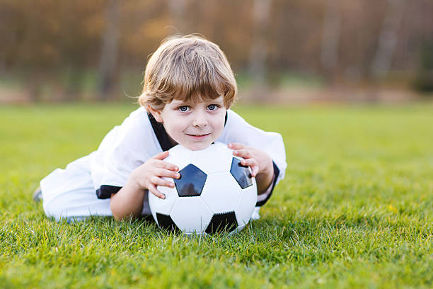 kleinen ventilator junge im öffentlichen anzeige des fußball oder fußball - playing field goalie soccer player little boys stock-fotos und bilder