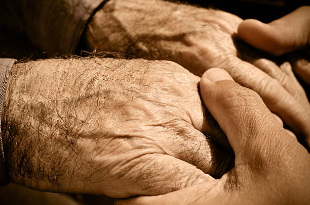 istock young man holding the hands of an old man 500041321