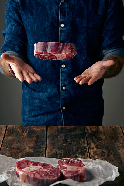 istock Tattoed butcher throws meat steak in the air 500045310