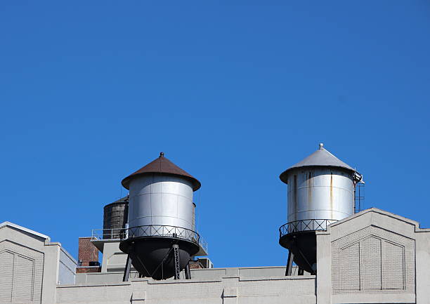 istock Water Tanks on Building Roof with Blue Sky Background 500045322