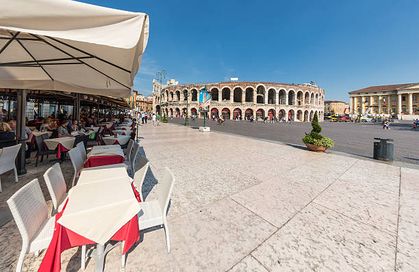 Relaxing next to Arena di Verona, Italy Verona, Italy - June 11, 2014. People are relaxing in bars at Piazza Bra in Verona next to the famous Roman Amphitheater. verona opera stock pictures, royalty-free photos & images