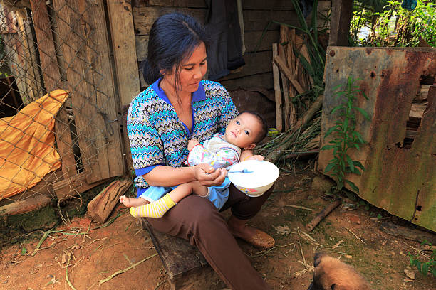 Lam Dong Province, Vietnam - November 7, 2015: A view of daily life from ethnic minority family in the highlands. The mother are feeding your baby 
