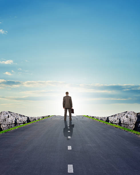 istock Businessman in suit walking on road with mountains 500049282