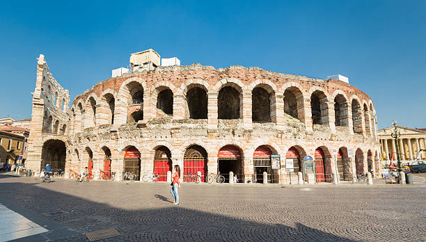 Summer Afternoon in Verona, Italy Verona, Italy - June 11, 2014. A female is crossing Piazza Bra next to the Arena di Verona consider to buy tickets for an italian opera at the ticket Counter. verona opera stock pictures, royalty-free photos & images