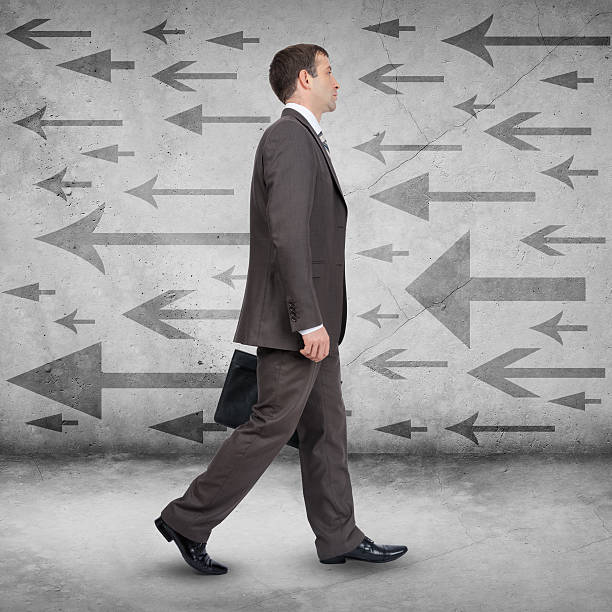 istock Businessman walking against arrows 500056658