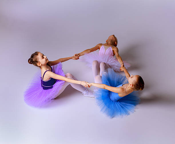 istock Three little ballet girls sitting in tutu and posing together 500057566